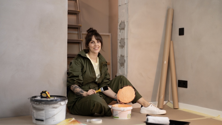 Woman sitting on the floor preparing to paint walls